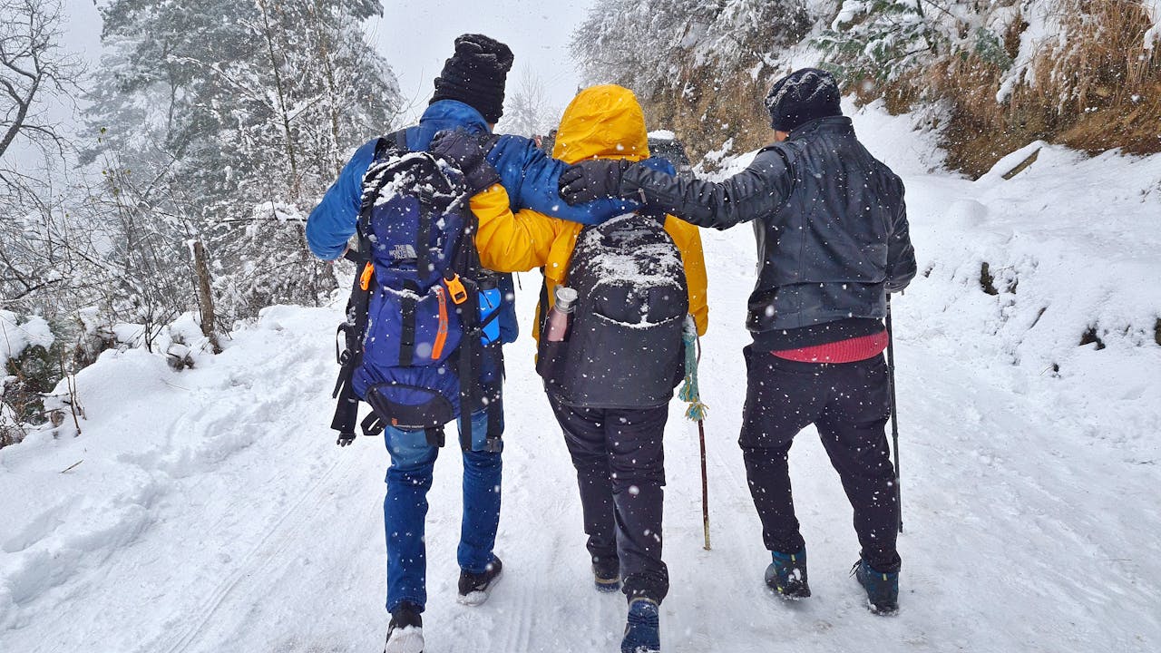 Group of friends hiking in snowy winter landscape in Sosan, India.